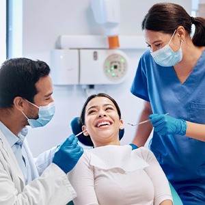 Patient smiling at dentist and dental assistant