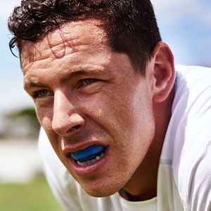 Man wearing blue mouthguard on field