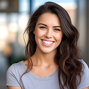 Closeup of woman in grey shirt smiling outside