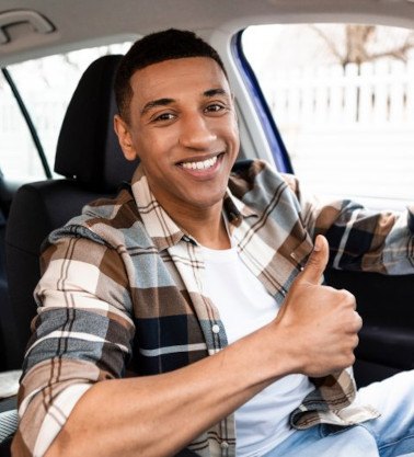 Man smiles in car