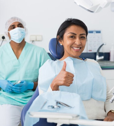 a patient giving a thumbs up before getting dental care