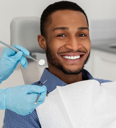 a patient smiling before undergoign a dental checkup