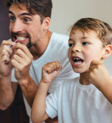 father and son flossing their teeth